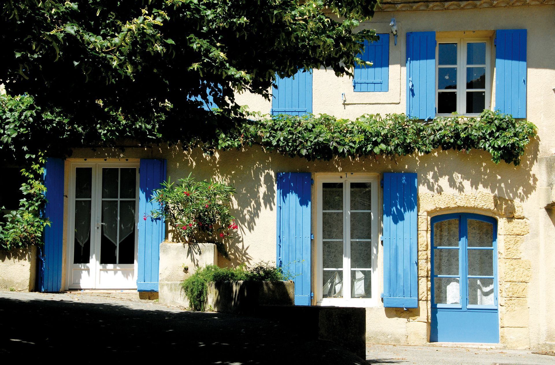 Façade d'une maison avec les volets bleus.