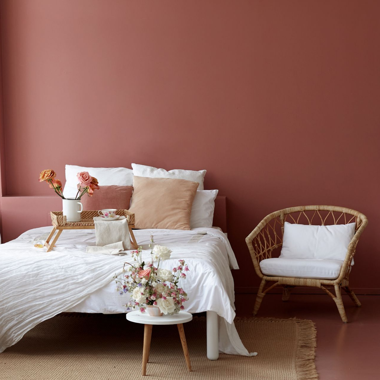 Chambre à coucher avec un lit et mur peint en couleur terracotta.