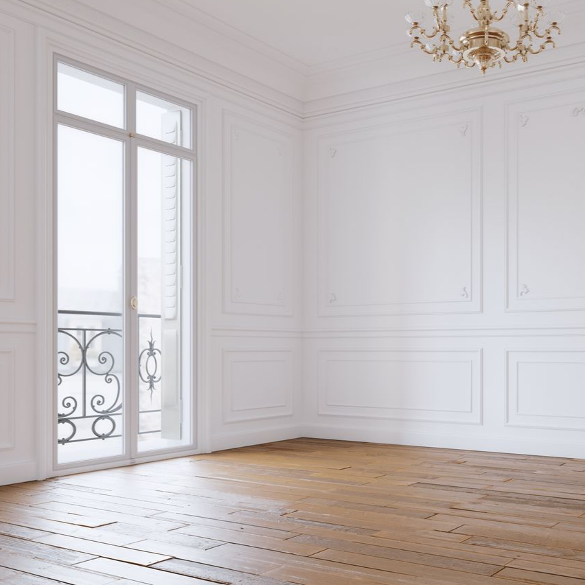 Pièce de vie avec le parquet en bois et des murs blancs.