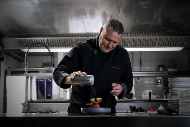 Cuisinier faisant couler de la sauce dans une assiette