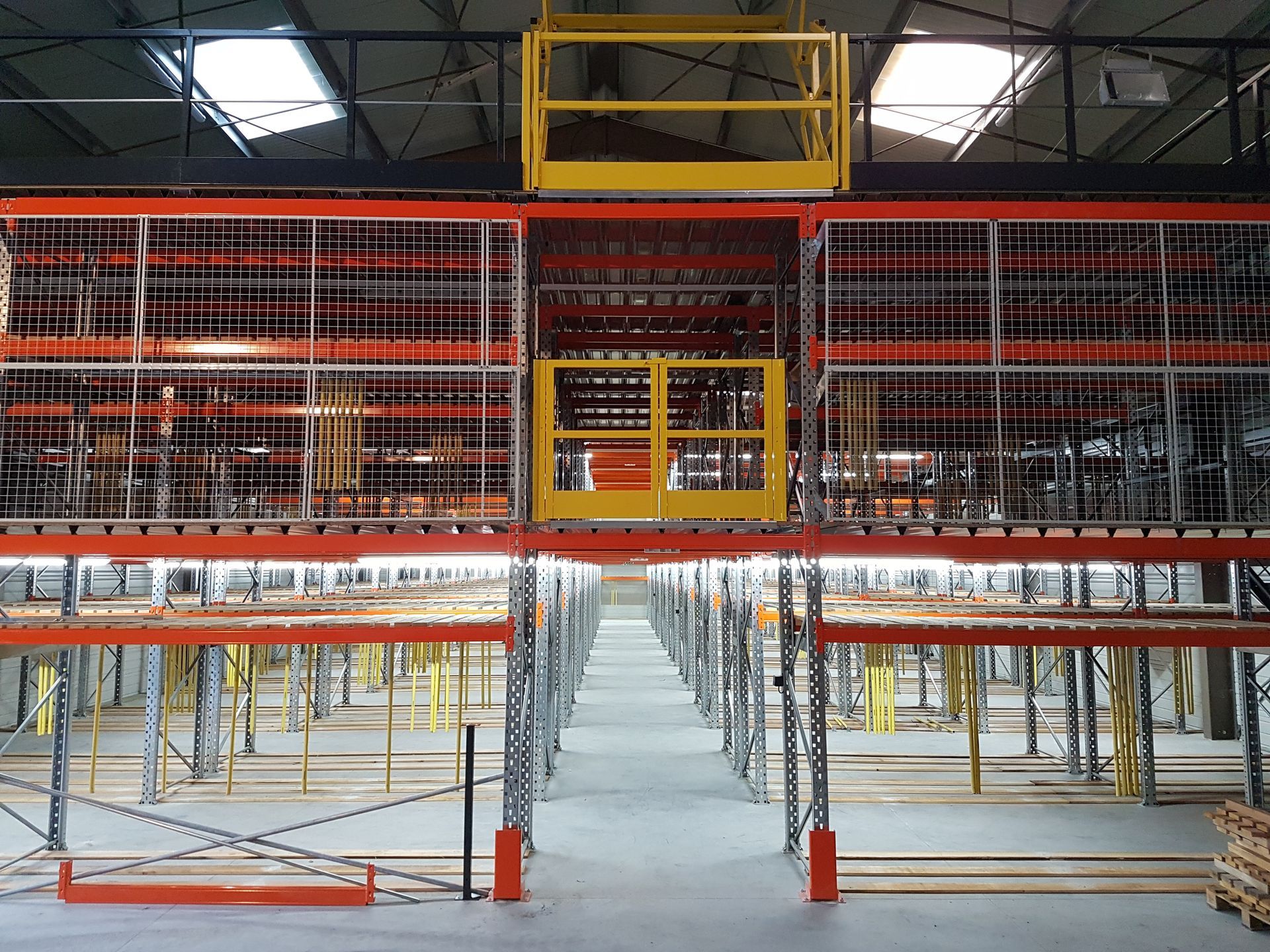 Intérieur d'entrepôt avec un système d'étagères hautes et un monte-charge jaune.