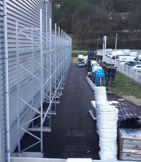 Étagères de rangement métalliques le long d'un bâtiment, en extérieur.