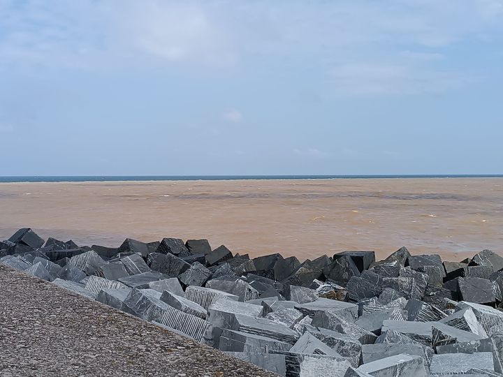 Photo d'une plage de sable fin avec des pierres volcaniques

