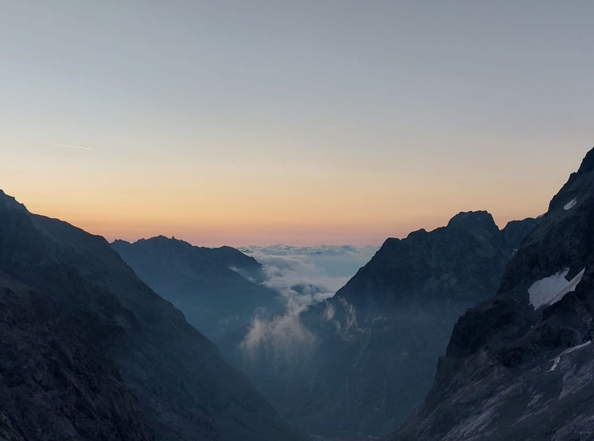 Montagne sombre avec quelques nuages durant un coucher de soleil