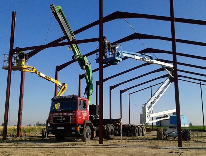 Un camión de carga está estacionado frente a un edificio en construcción.