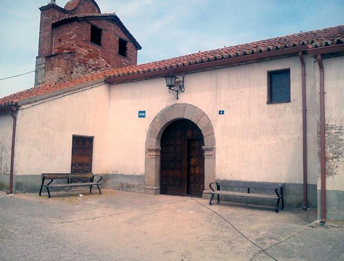Una iglesia con dos bancos delante de ella.