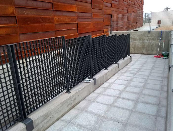 Una valla con una pared de madera detrás.