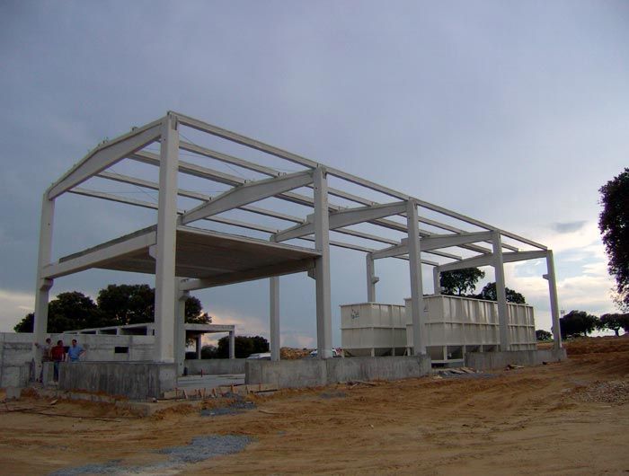 Un edificio que se está construyendo en medio de un campo de tierra.