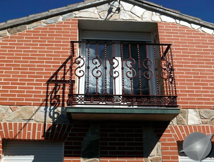 Un edificio de ladrillo con balcón y antena parabólica.