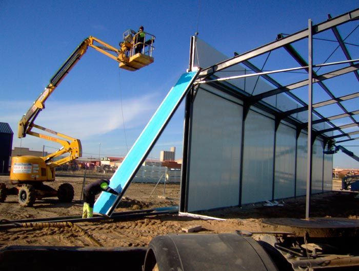 Una grúa amarilla está levantando un trozo de espuma azul.