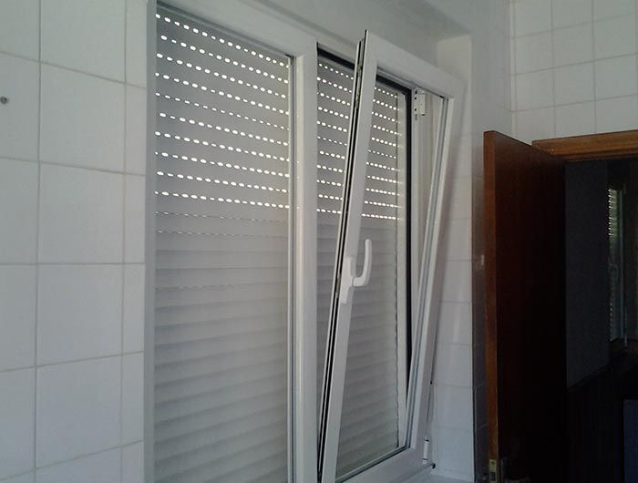 Una ventana blanca con contraventanas está abierta.