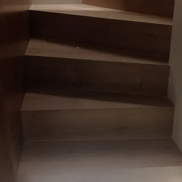 Un primer plano de un conjunto de escaleras de madera en una habitación.
