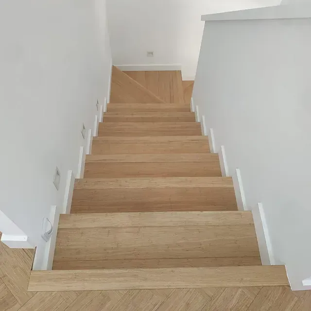 Un conjunto de escaleras de madera que conducen al segundo piso de una casa.
