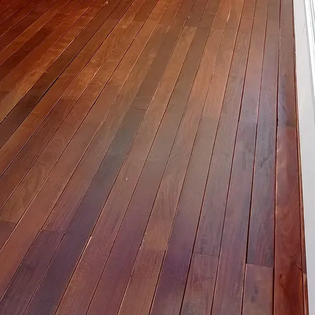 Un primer plano de un piso de madera con molduras blancas.