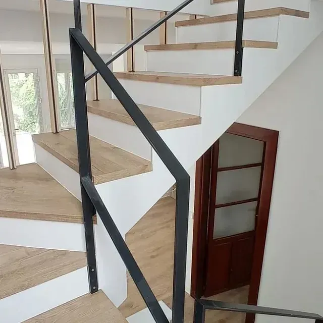 Una escalera con escalones de madera y barandilla de metal