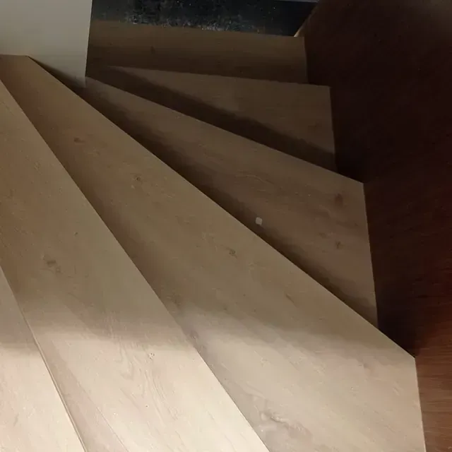 Un primer plano de una escalera de madera en una casa.