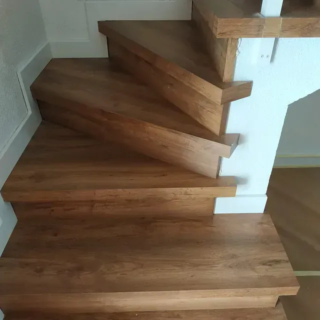 Las escaleras son de madera y tienen barandilla blanca.