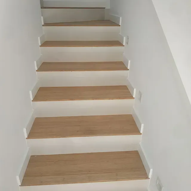 Un conjunto de escaleras con escalones de madera y paredes blancas.