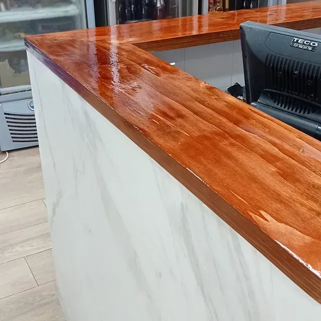 Una encimera de madera con un monitor de computadora encima.