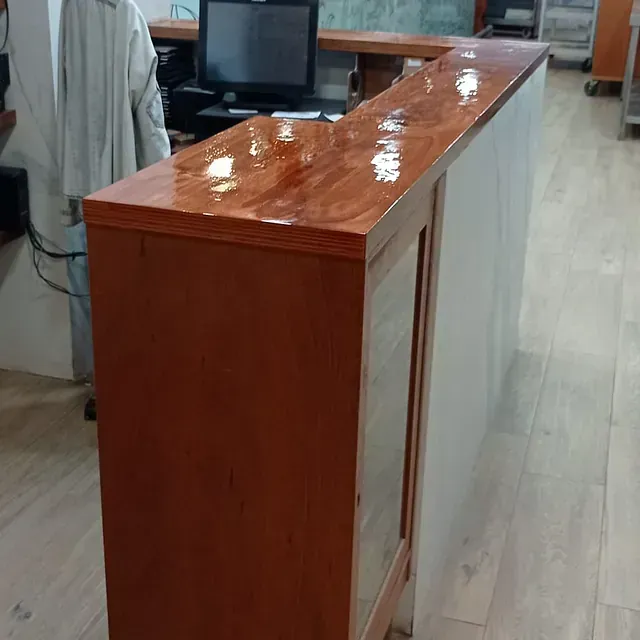 Un mostrador de madera con una computadora encima.