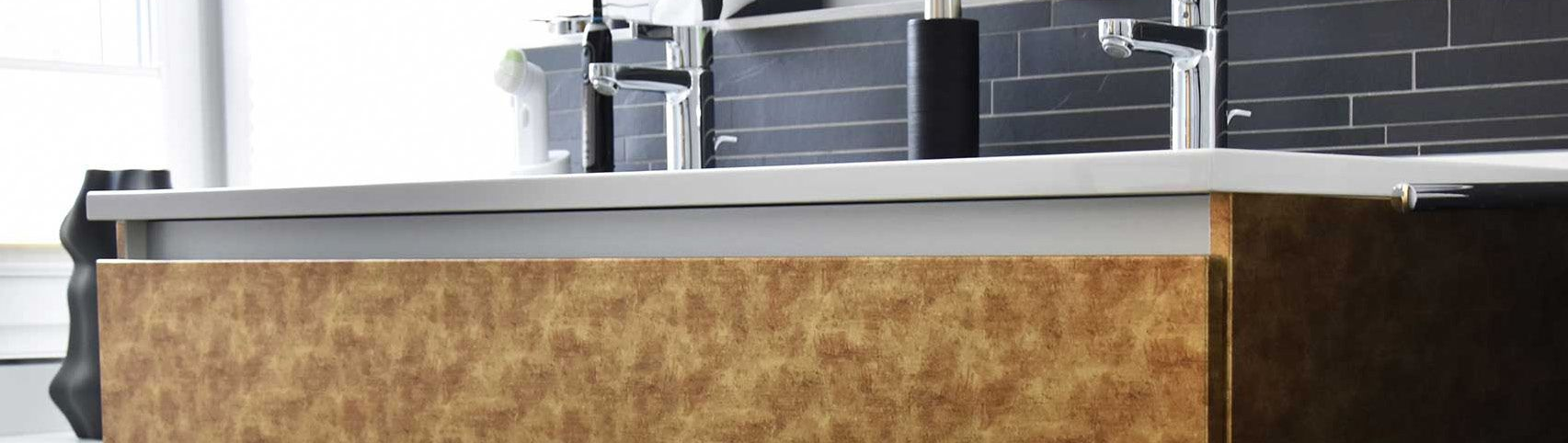 Gros plan sur un meuble de salle de bains avec un covering brun clair avec deux lavabos blancs. 