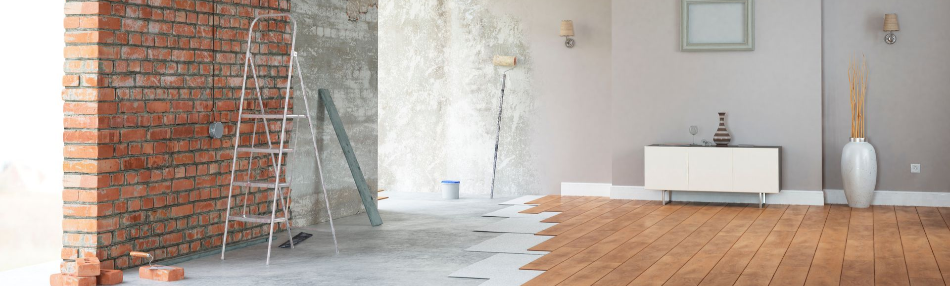 Pièce en cours de rénovation, montrant un mur de briques se transformant en un intérieur moderne et fini avec un parquet.
