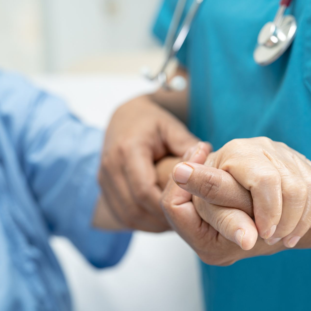 Un professionnel de santé tient la main d'une patiente