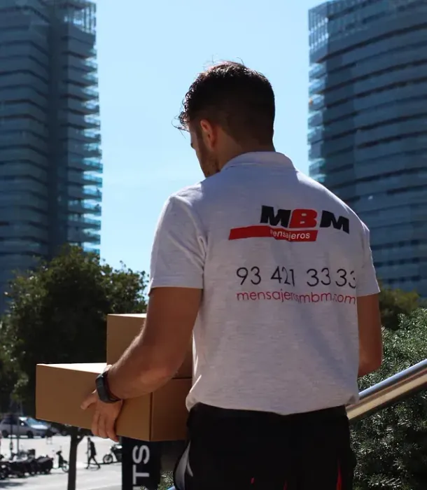 Un hombre que lleva una camiseta de MBM lleva una caja.