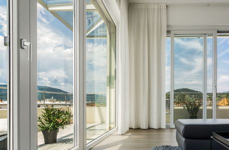 Baie vitrée avec vue sur les collines.