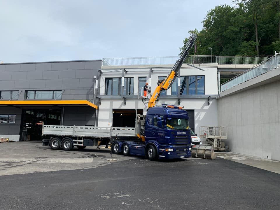 ein blauer Scania-Lkw steht vor einem Gebäude