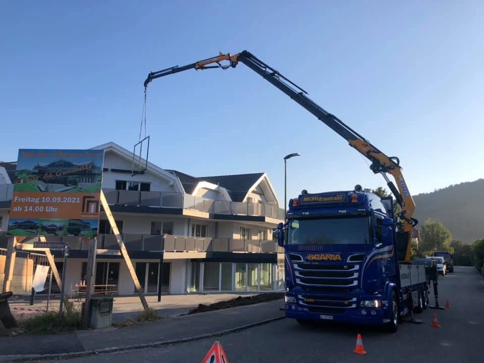 ein blauer Scania-Lkw steht vor einem Gebäude
