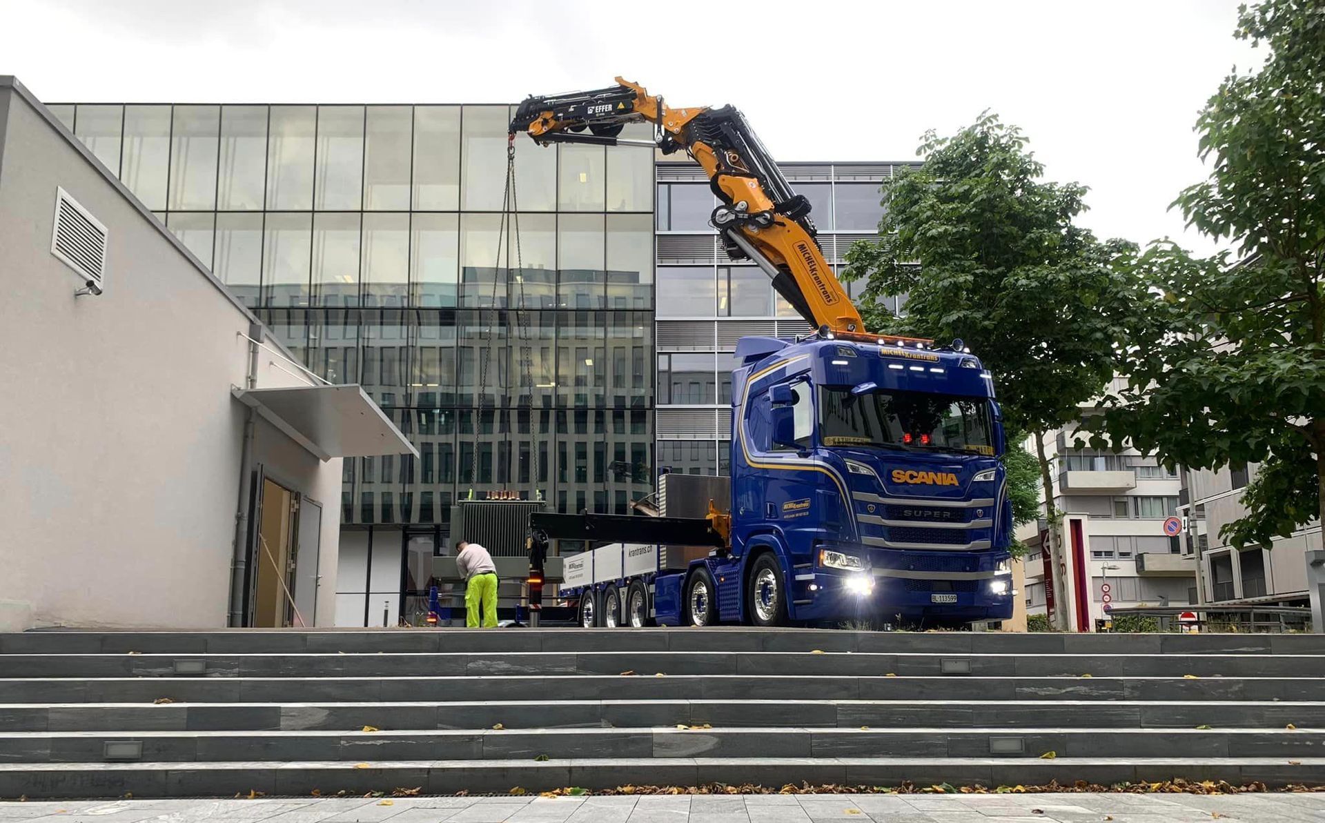 ein blauer Scania-Lkw steht vor einer Treppe