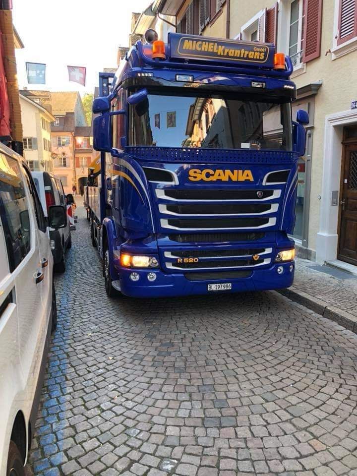 ein blauer Scania-Lkw fährt auf einer gepflasterten Straße