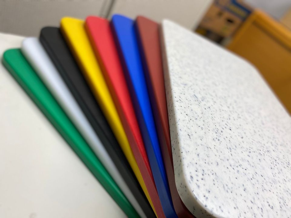 Verschiedene bunte Schneidebretter in einer Reihe gestapelt.