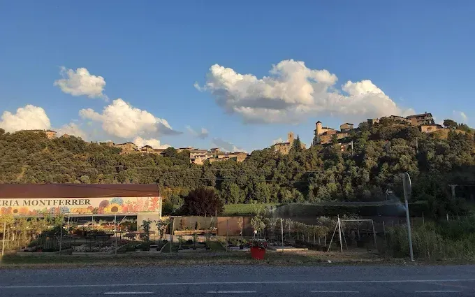 Un edificio al costado de una carretera con una montaña al fondo.