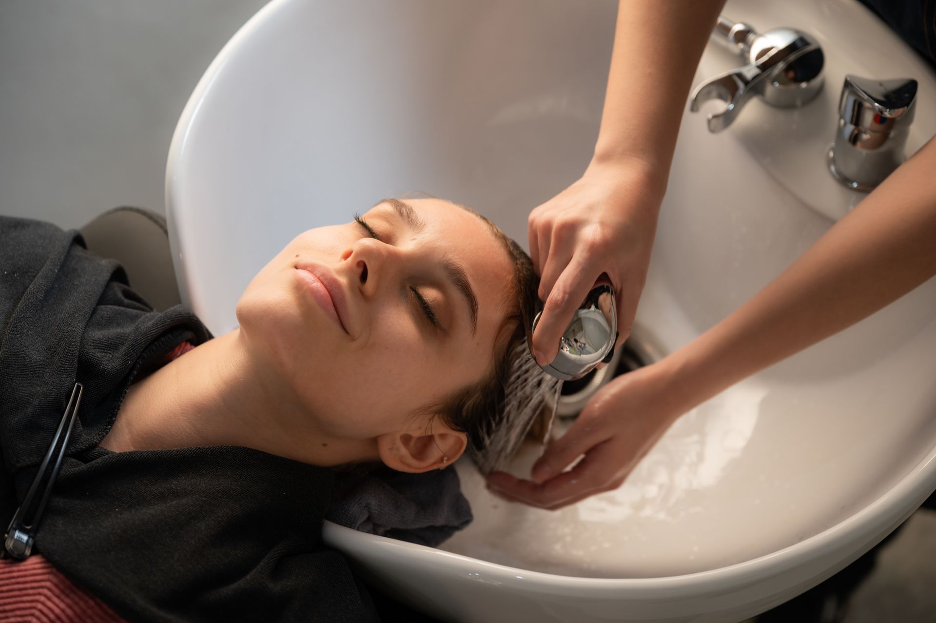 Une personne se faisant laver les cheveux dans un salon de coiffure.