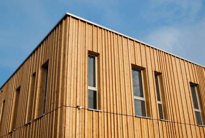 Façade d'un bâtiment en bois avec des lattes verticales et des fenêtres étroites