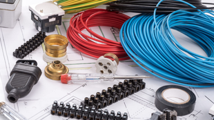 Composants de câblage électrique, y compris les câbles rouge et bleu, sur un plan.