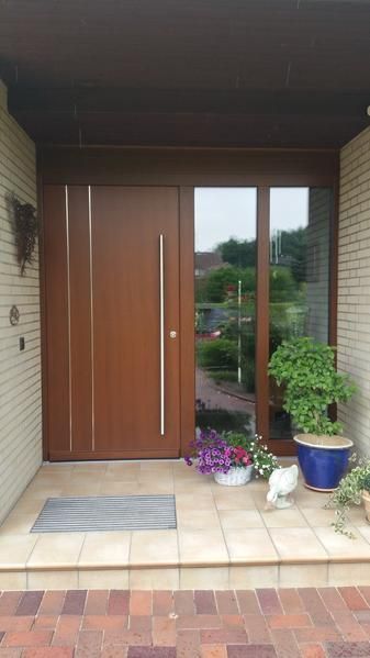 Die Haustür eines Hauses mit einer Holztür und einer Glastür.