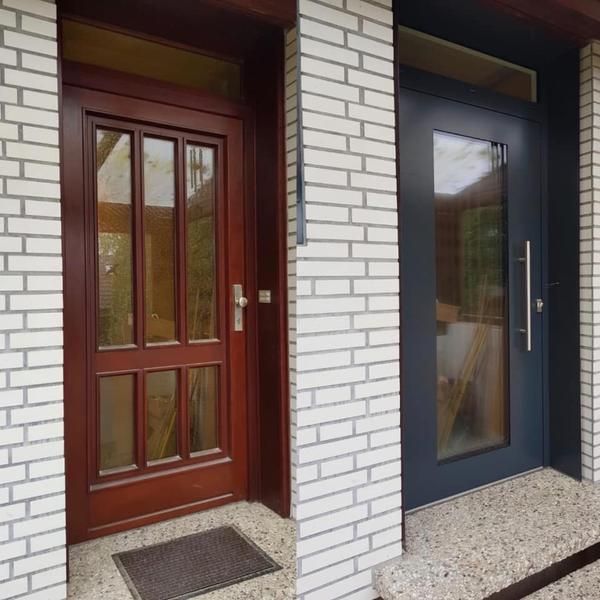 Eine Holztür und eine schwarze Tür liegen nebeneinander