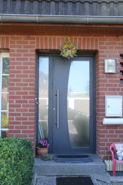 Die Eingangstür eines Backsteinhauses mit einer grauen Tür