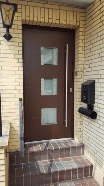 Ein Backsteingebäude mit einer braunen Tür und Treppe