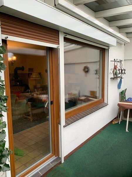 Ein Haus mit einem großen Fenster und einer Glasschiebetür