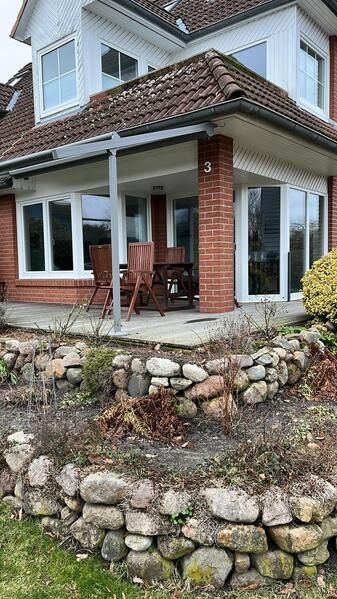 Ein großes Backsteinhaus mit einer Steinmauer davor.