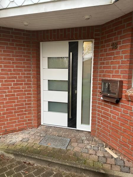 Ein Backsteingebäude mit einer weißen Tür und einem Briefkasten.