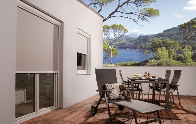 Eine Terrasse mit Tisch und Stühlen und Blick auf einen See