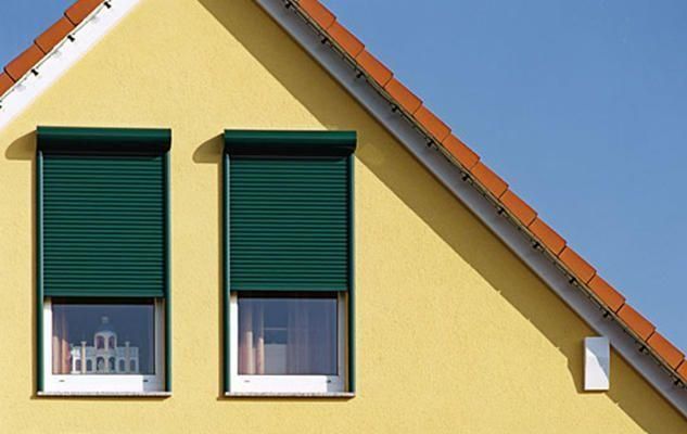 Ein gelbes Haus mit grünen Fensterläden