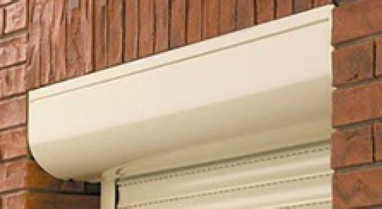 Eine Nahaufnahme eines weißen Rollladens an einer Ziegelwand.