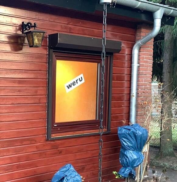 Ein Holzgebäude mit einem Fenster, auf dem 