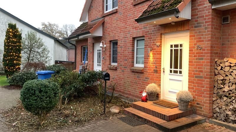 Ein Backsteinhaus mit einer weißen Tür und einem Briefkasten davor.